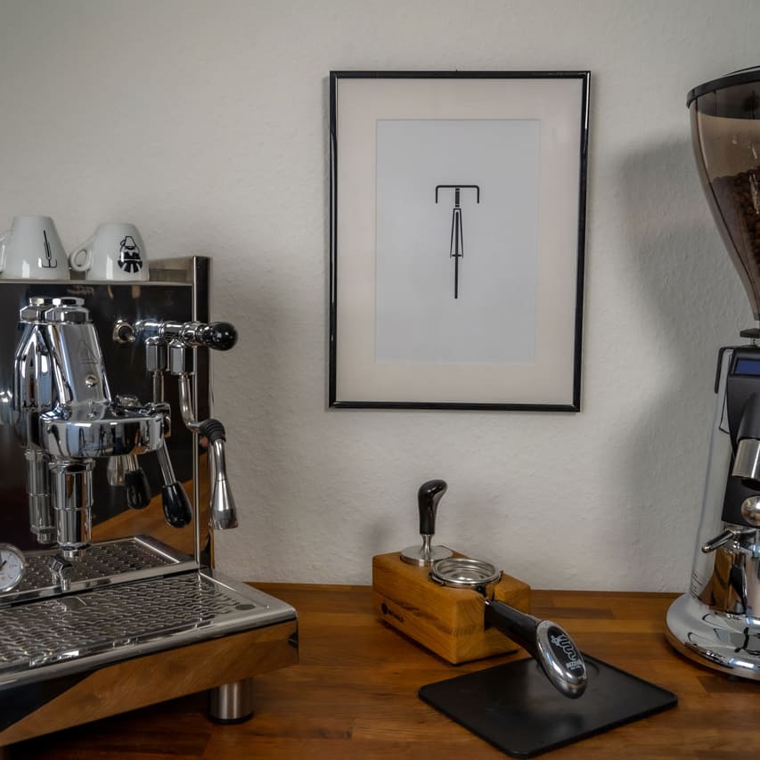 Das Poster "Bike" hängt im Bilderrahmen an der Wand zwischen einer Kaffeemaschine und einer Kaffeemühle.