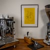 Das Poster "Rad Scribble" hängt im Bilderrahmen an der Wand zwischen einer Kaffeemaschine und einer Kaffeemühle
