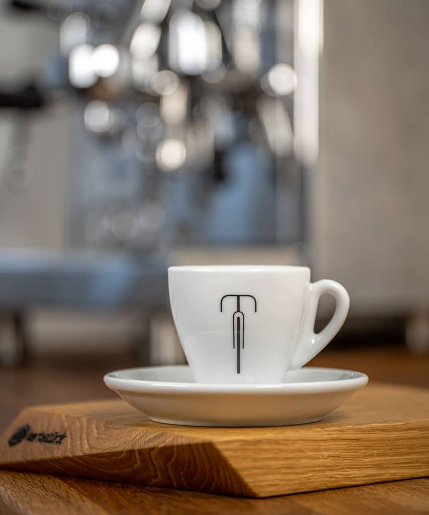 Eine weiße Espresso-Tasse mit einem stilisierten Rennrad.